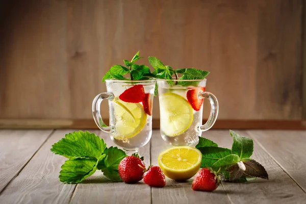 Fresh summer healthy drink with lemon and strawberries with ice. — Stock Photo, Image