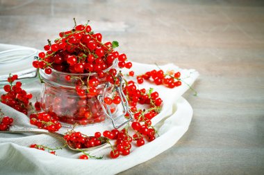 Ahşap bir masa üzerinde olgun kırmızı kuş üzümü.