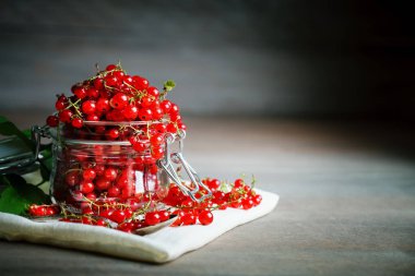 Ahşap bir masa üzerinde olgun kırmızı kuş üzümü.