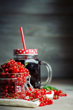 Olgun kırmızı kuş üzümü ve ahşap bir masa üzerinde Siyah frenk üzümü suyu.