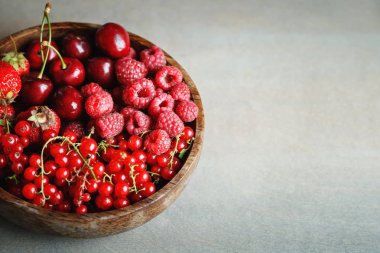 Ahşap bir masa üzerinde bir tabak içinde olgun çilek.