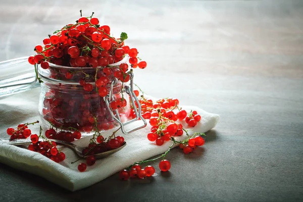 Ahşap bir masa üzerinde olgun kırmızı kuş üzümü.