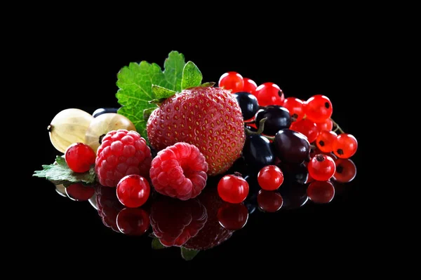 Bayas maduras de grosella roja, fresas, frambuesas y grosellas sobre un fondo negro . —  Fotos de Stock