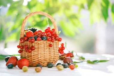 Ahşap bir masa üzerinde bir sepet içinde olgun çilek.