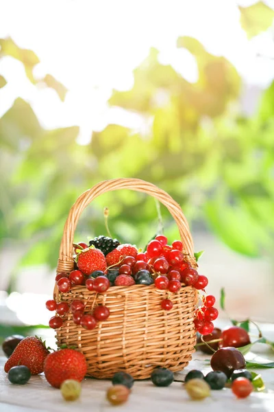 Ahşap bir masa üzerinde bir sepet içinde olgun çilek.