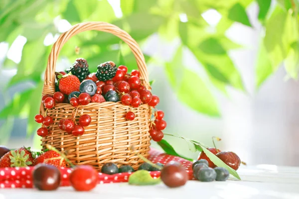 Спелые ягоды в корзине на деревянном столе . — стоковое фото