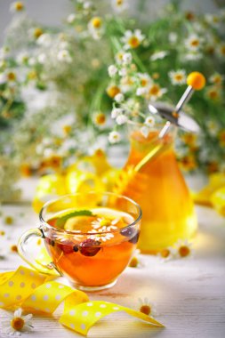 Çay, bir kavanoz bal ve çiçek sağlıklı bir fincan. Seçici odak.