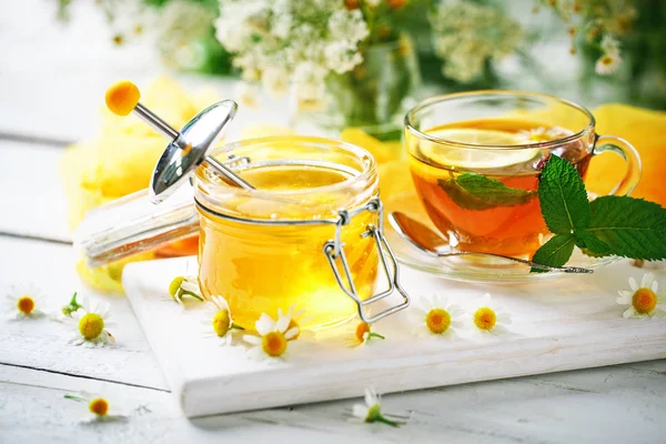 Çay, bir kavanoz bal ve çiçek sağlıklı bir fincan. Seçici odak. — Stok fotoğraf