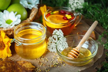 Taze bal, polen ve ahşap bir masa üzerinde olgun elma. Seçici odak.