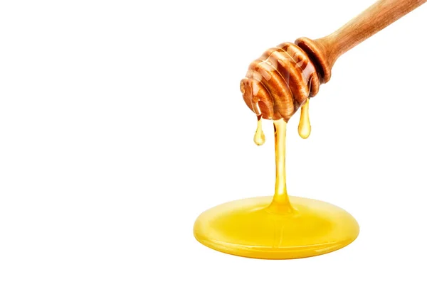 Fresh honey dripping from a spoon. On a white background. — Stock Photo, Image