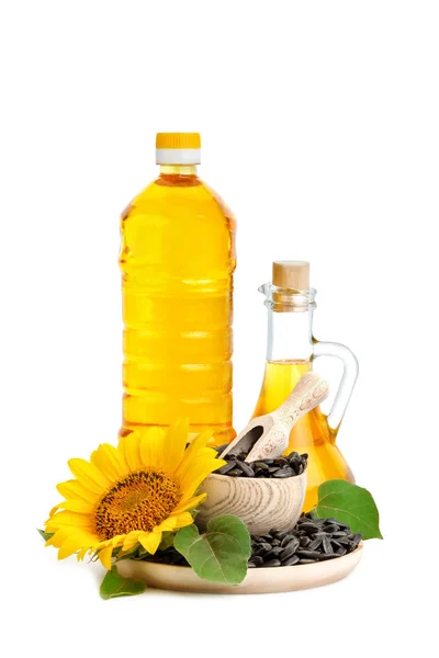 Hermosa flor, girasol, aceite de girasol y semillas de girasol tostadas sobre un fondo blanco . —  Fotos de Stock