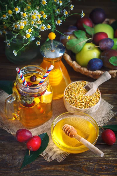 Frischer Honig, Feldblumen, Zitronentee und Obst auf einem Holztisch. Selektiver Fokus. — Stockfoto