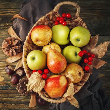 Taze elma ve armut ahşap bir masa üstünde sepetle. Sonbahar arka plan.