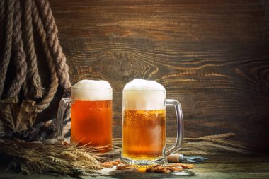 Ahşap bir masa üzerinde taze bira gözlük.