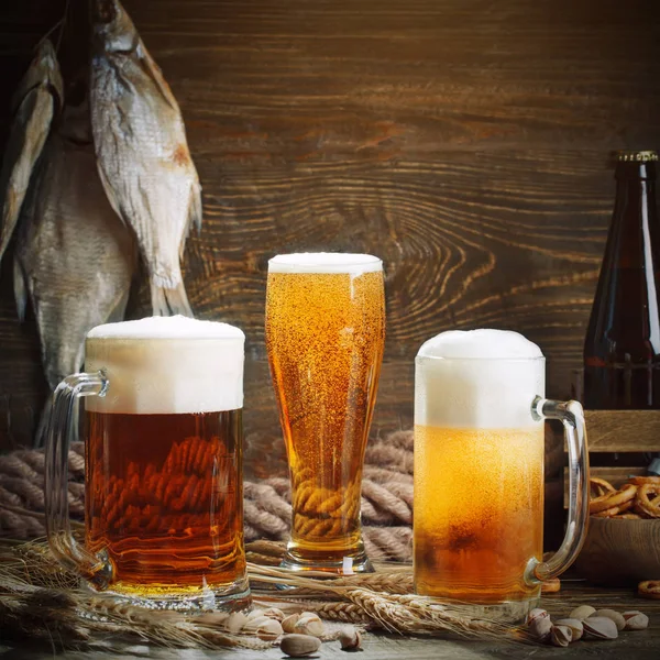 Sklenice piva a sušených ryb na dřevěný stůl. — Stock fotografie