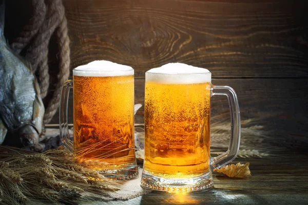 Glazen bier en gedroogde vis op een houten tafel. — Stockfoto