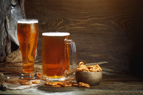 Copos de cerveja e peixe seco em uma mesa de madeira . — Fotografia de Stock