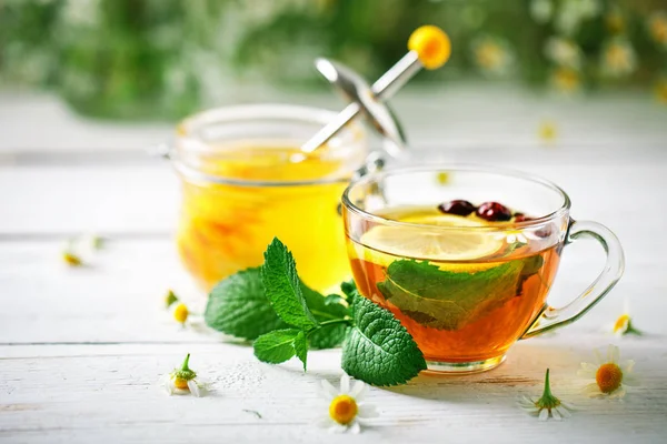 Eine gesunde Tasse Tee, ein Glas Honig und Blumen. Selektiver Fokus. — Stockfoto