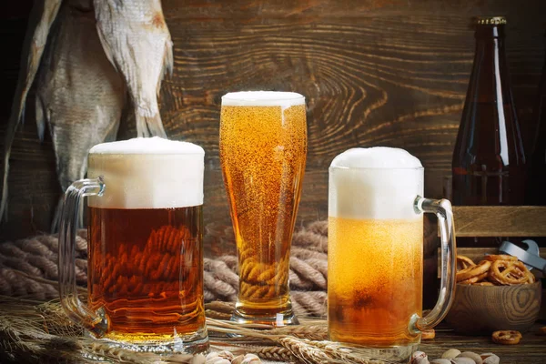 Vasos de cerveza y pescado seco sobre una mesa de madera . — Foto de Stock