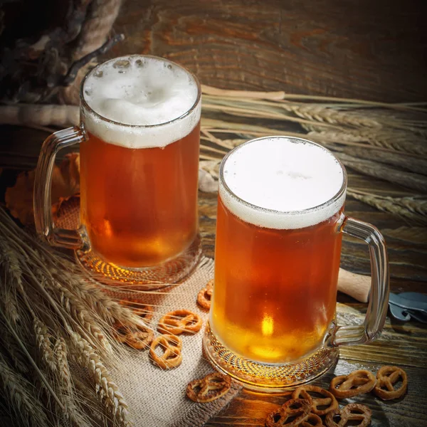 Vasos de cerveza fresca sobre una mesa de madera . — Foto de Stock