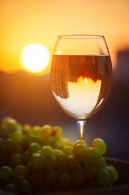 Gün batımında, evlerin yansıması ile beyaz şarap.