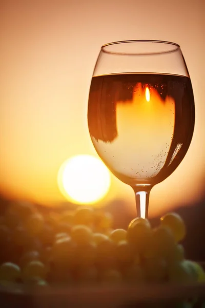 Ein Glas Weißwein bei Sonnenuntergang, mit dem Spiegelbild der Häuser. — Stockfoto
