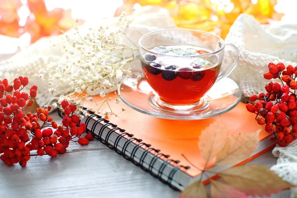 Fincan çay, Rowan ve ahşap masa üstünde not etmek. Sonbahar natürmort.