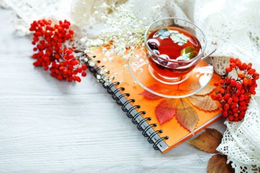 Fincan çay, Rowan ve ahşap masa üstünde not etmek. Sonbahar natürmort.