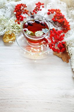 Bir fincan çay ve üvez meyveleri ahşap bir masa üzerinde. Sonbahar natürmort.