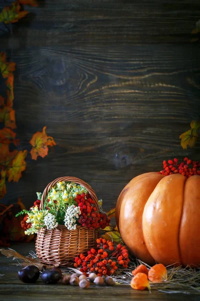 Ahşap masa vahşi kabaklar ve sonbahar yaprakları tarafından çiçeklerle süslenmiş. Sonbahar arka plan. Mutlu Şükran günü arka plan.
