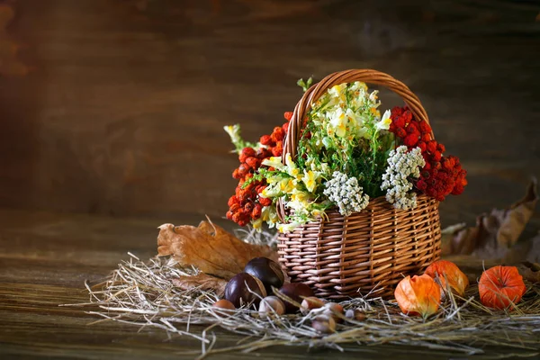 Holztisch mit Wildblumen, Vogelbeeren und Herbstblättern. — Stockfoto