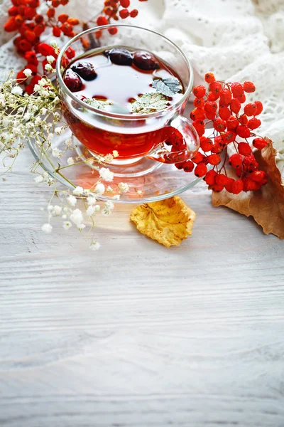 Eine Tasse Tee und Vogelbeeren auf einem Holztisch. Herbst-Stillleben. — Stockfoto