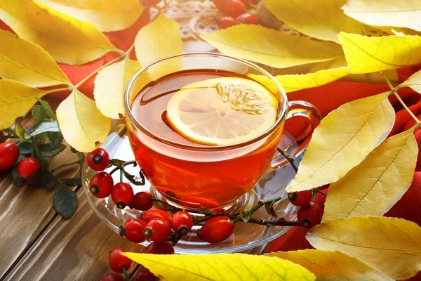 Tablo, sonbahar yaprakları, taze çay ve çilek ile dekore edilmiştir. Sonbahar. Sonbahar arka plan.