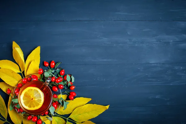 Der Tisch, dekoriert mit Herbstblättern, Beeren und frischem Tee. Herbst. Hintergrund Herbst. — Stockfoto