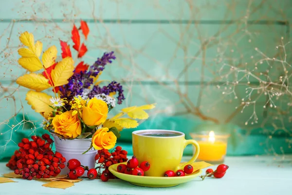 Una taza de café, hojas de otoño y flores sobre una mesa de madera. Bodegón de otoño. Enfoque selectivo . — Foto de Stock