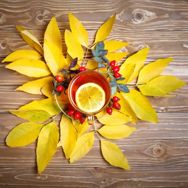 La mesa, decorada con hojas de otoño, bayas y té fresco. Otoño. Fondo de otoño . — Foto de Stock