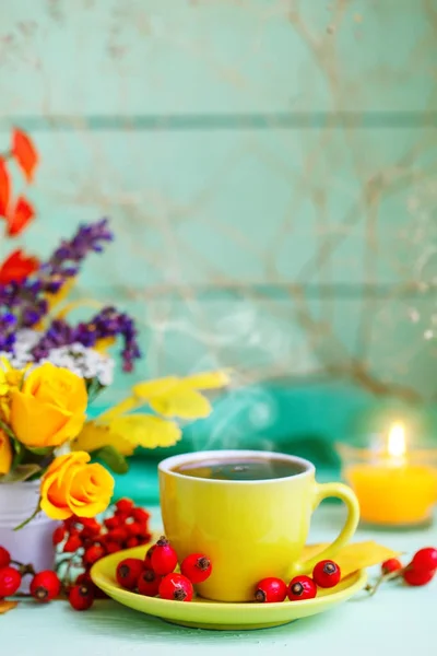 Una taza de café, hojas de otoño y flores sobre una mesa de madera. Bodegón de otoño. Enfoque selectivo . — Foto de Stock
