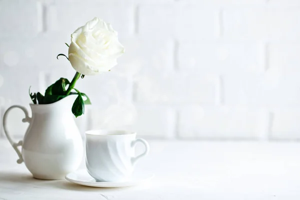 부드러운 화이트 로즈 꽃병에 한 잔의 커피. 선택적 초점입니다. 배경 복사 공간. — 스톡 사진
