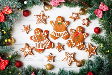 Yıldızlar, kar taneleri şeklinde el yapımı zencefilli kurabiye, Noel için insanlar ve yeni yıl tatili beyaz ahşap bir masada..