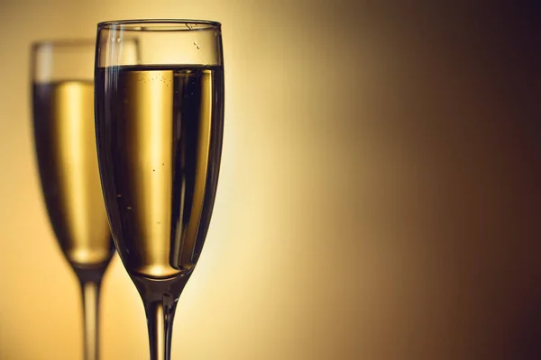 Due bicchieri di champagne su sfondo sfocato. Concetto di celebrazione. Concentrazione selettiva. Sfondo con spazio di copia . — Foto Stock