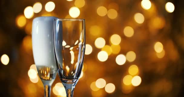 Champagner wird vor dem Hintergrund der Neujahrsgirlanden in Gläser gegossen.