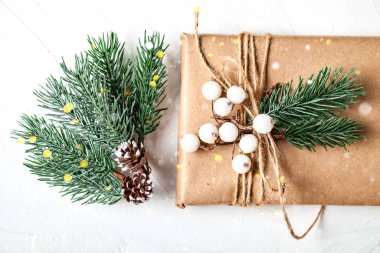 Mutlu Noeller ve mutlu yıllar. Kartpostallı bir model ve beyaz arka planda bir Noel ağacı dalları. Fotokopi alanı olan bir arka plan. Seçici odaklanma. Üst Manzara. Noel arkaplanı.