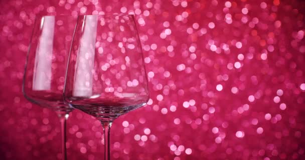 Le vin rouge est versé dans des verres sur le fond du bokeh. Gros plan sur le remplissage du verre à vin avec du vin rouge. Tir au ralenti. 4K . — Video