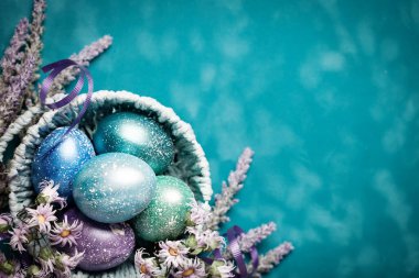 Mutlu Paskalyalar. Paskalya arkaplanını tebrik ederim. Paskalya yumurtaları ve çiçekler. Kopya alanı olan bir arkaplan. Seçici odaklanma. Üst görünüm.