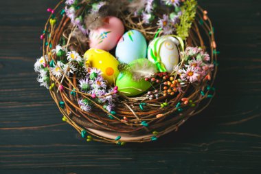 Mutlu Paskalyalar. Paskalya arkaplanını tebrik ederim. Paskalya yumurtaları ve çiçekler. Kopya alanı olan bir arkaplan. Seçici odaklanma. Üst görünüm.