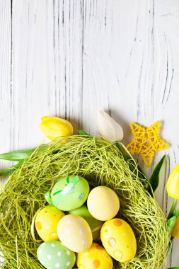 Mutlu Paskalyalar. Paskalya arkaplanını tebrik ederim. Paskalya yumurtaları ve çiçekler. Kopya alanı olan bir arkaplan. Seçici odaklanma. Üst görünüm.