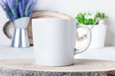 White mug on a background of flowers . Mock up. Template Space for creative artwork. Lettering text product promotion branding.