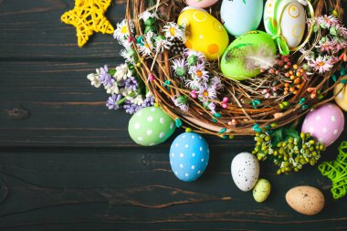 Mutlu Paskalyalar. Paskalya arkaplanını tebrik ederim. Paskalya yumurtaları ve çiçekler. Kopya alanı olan bir arkaplan. Seçici odaklanma. Üst görünüm.