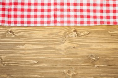 Tahta masadaki kırmızı kareli masa örtüsü. Kopya alanı olan bir arkaplan. Yatay olarak. Üst görünüm.