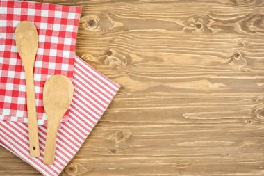 Red checkered tablecloth and wooden spoon for cooking and baking. Background with copy space. Horizontal.